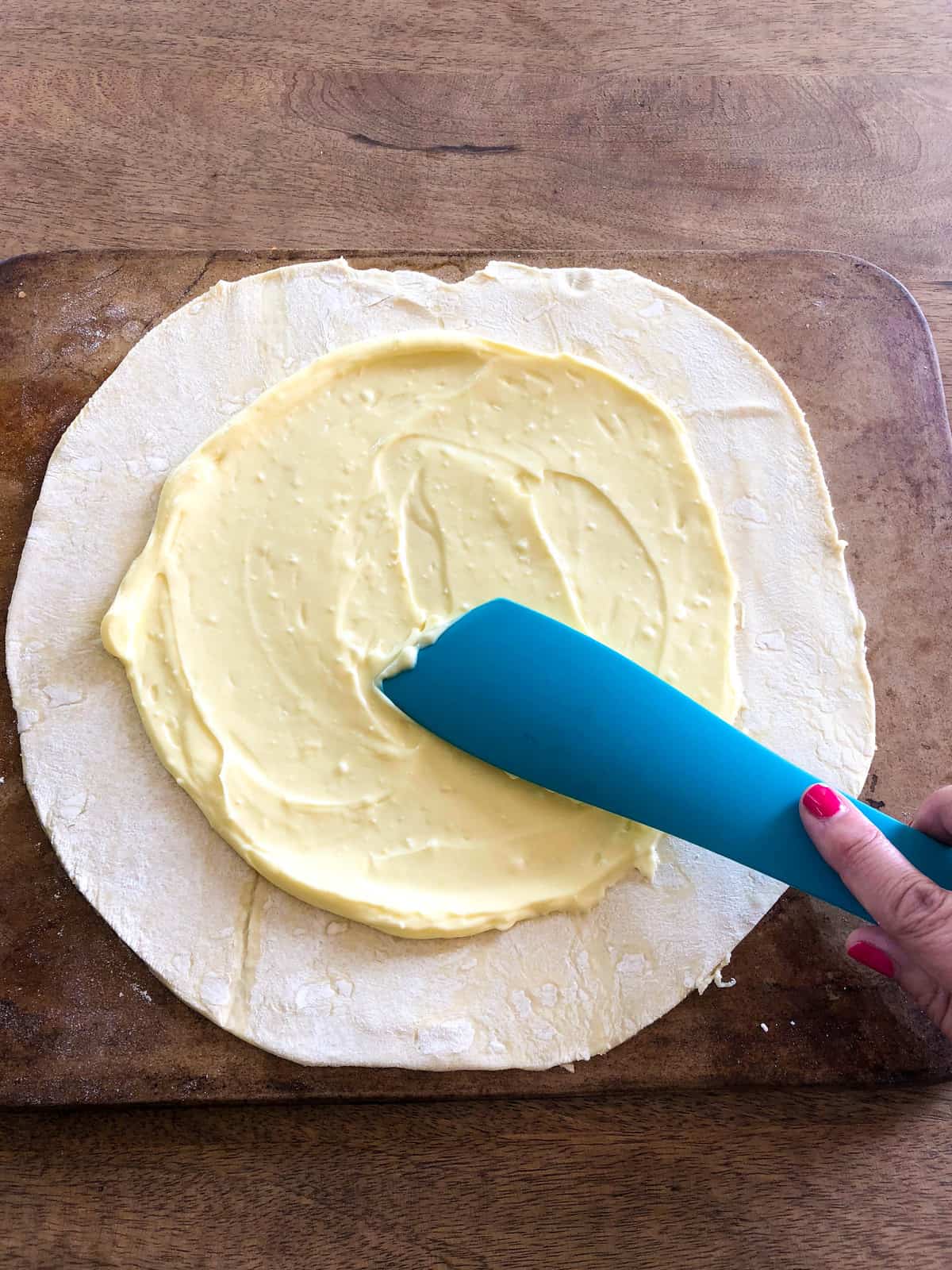 Spread the cream cheese mixture to within a few inches of the dough edges.