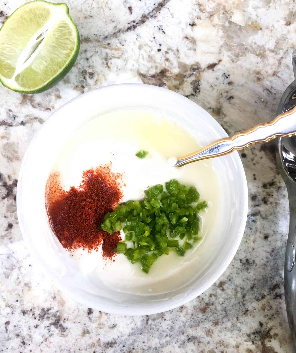Add the jalapenos into a bowl with the mayo, sour cream, chili powder and lime. 