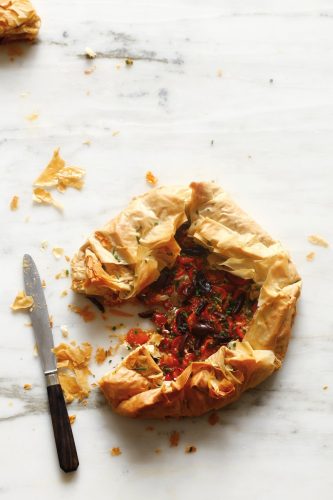 A rustic galette filled with tomatoes. The galette dough is flaky, golden layers of phyllo dough. 