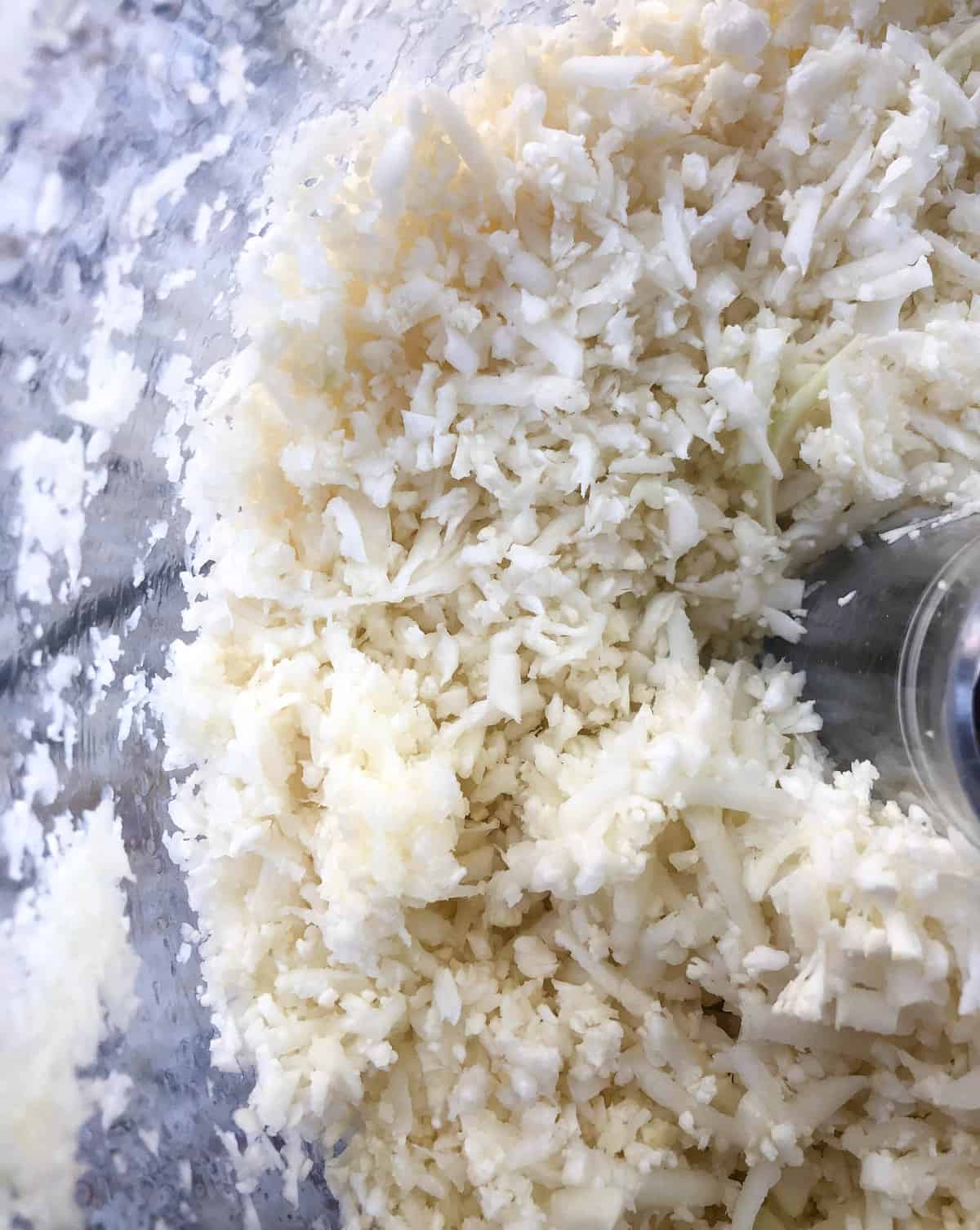Using the grater attachment, process the cauliflower through and you end up with this mixture that resembles small grains of rice.