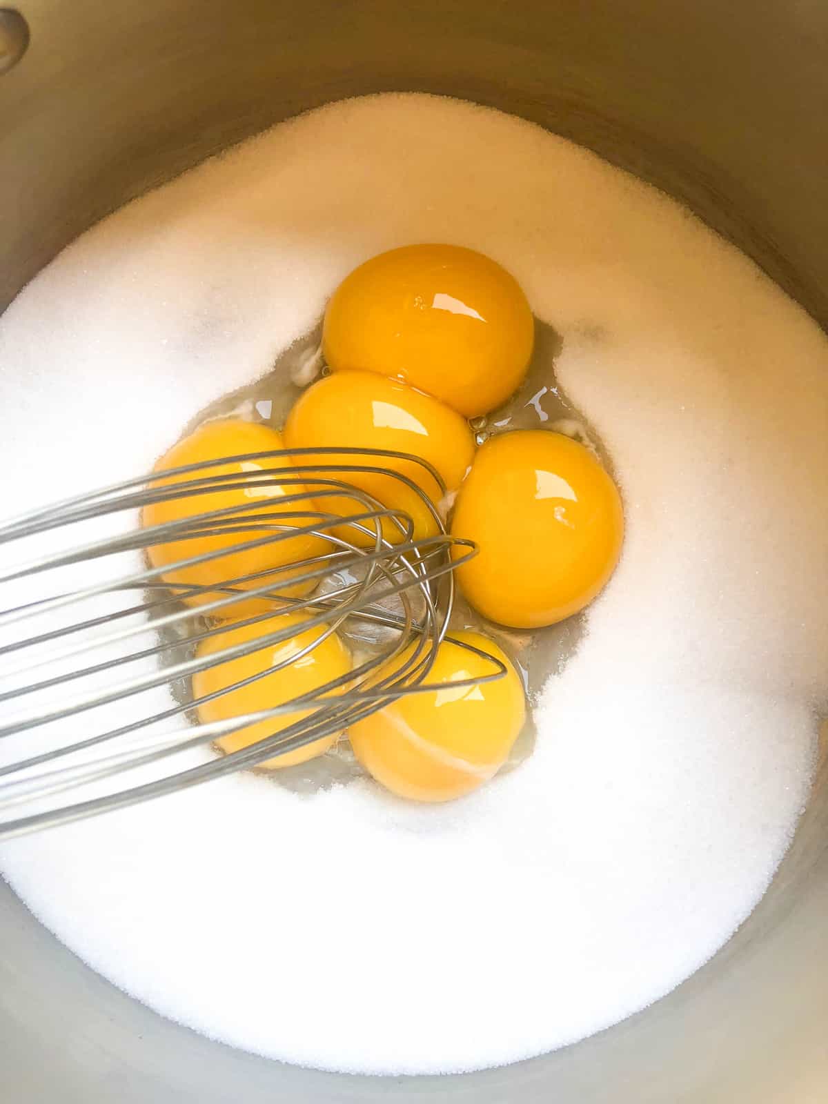 In a large saucepan, mix the egg yolks with the sugar and whisk over medium heat until thickened.