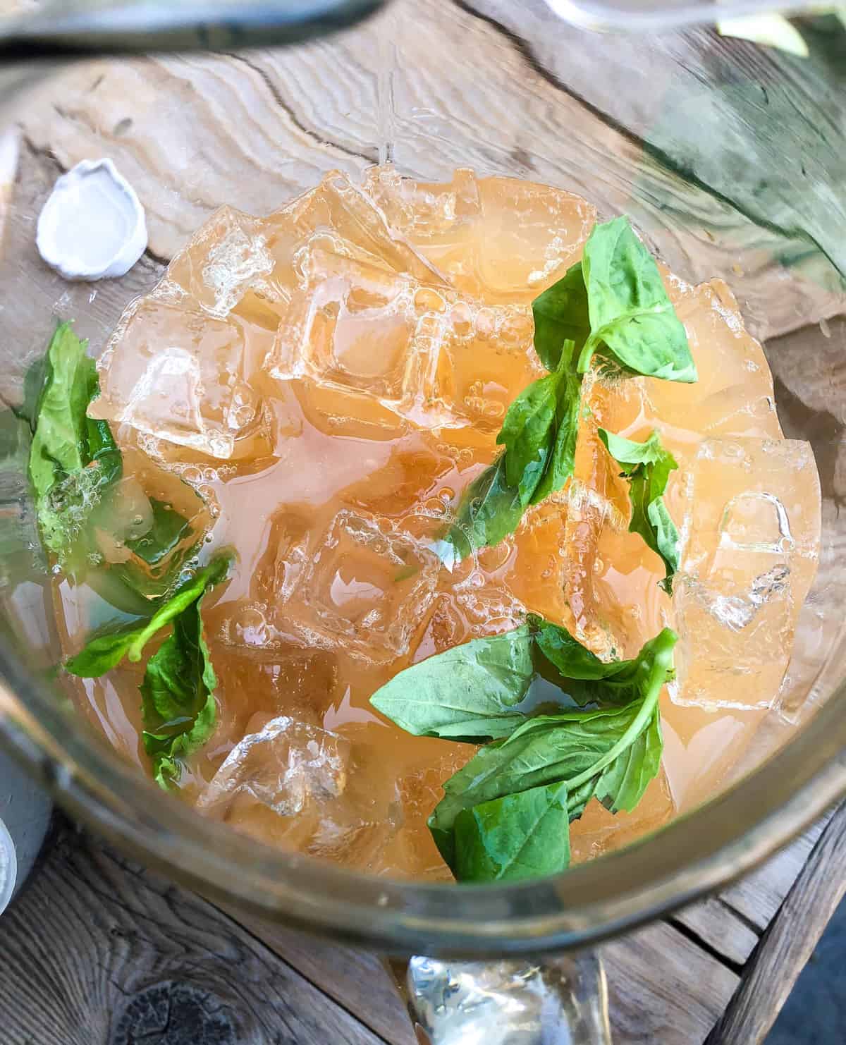 Fill the pitcher with ice and add the basil and apple juice.