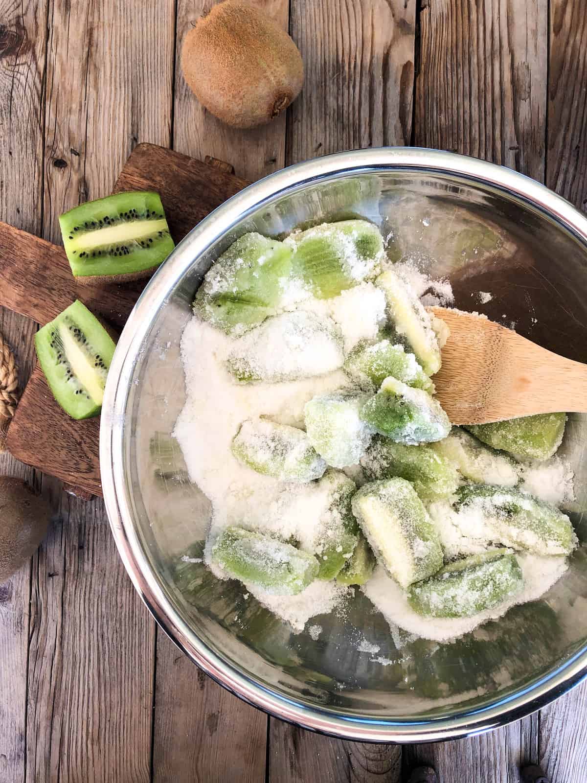 Stir the sugar to coat the kiwis. Cover and place in the fridge for about an hour.