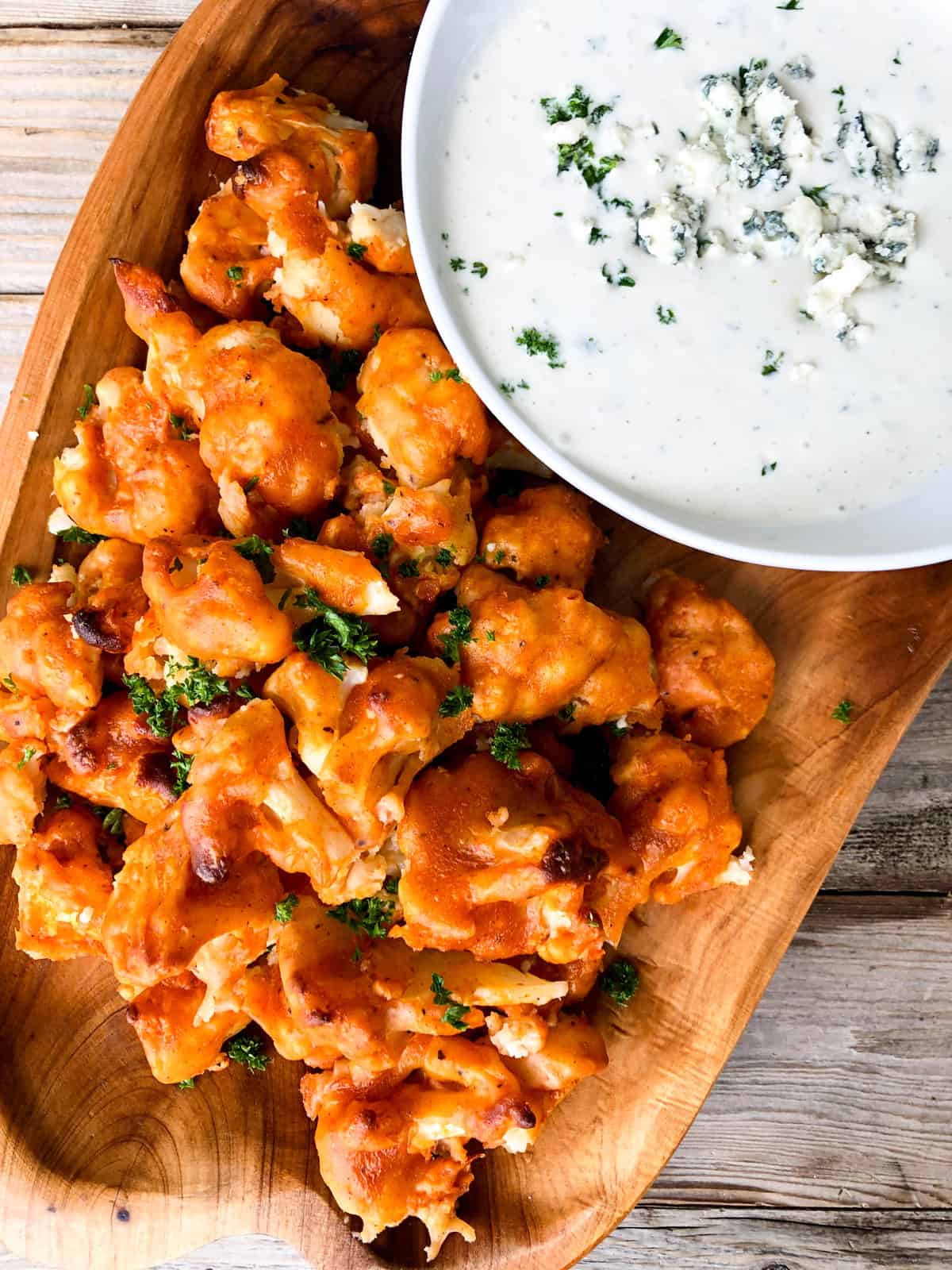 Dust the finished Buffalo Cauliflower with finely chopped parsley and serve with a blue cheese dip.
