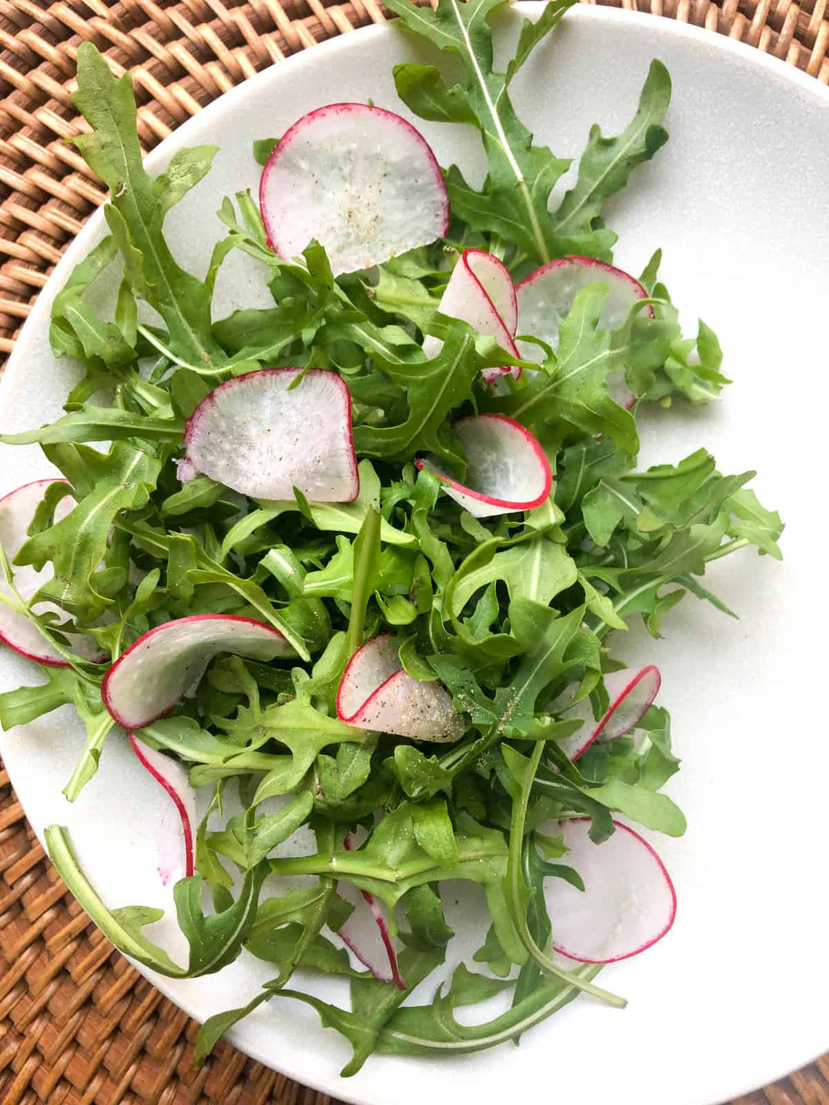 plate with fresh arugula and shaved radish rounds, sprinkled with a zesty lemon vinaigrette. 