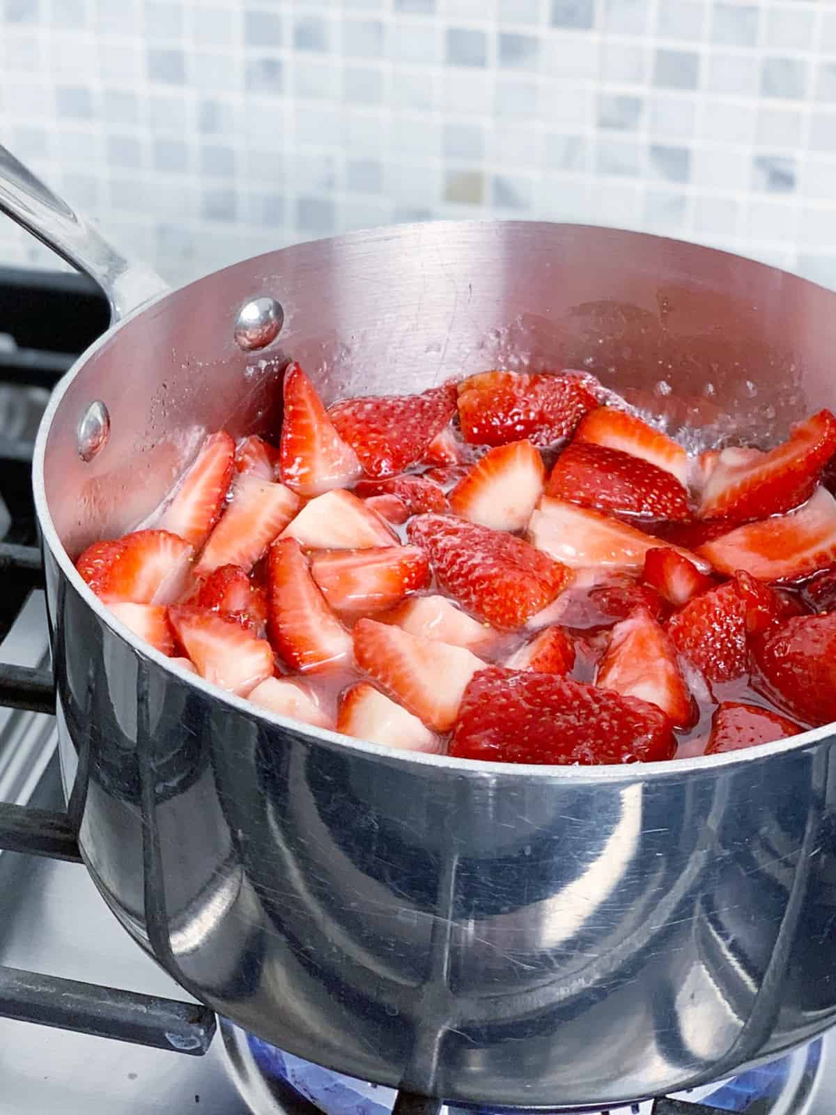 Stir occasionally. You will notice the sugar heat and turn to liquid. Continue cooking and bring to a boil.