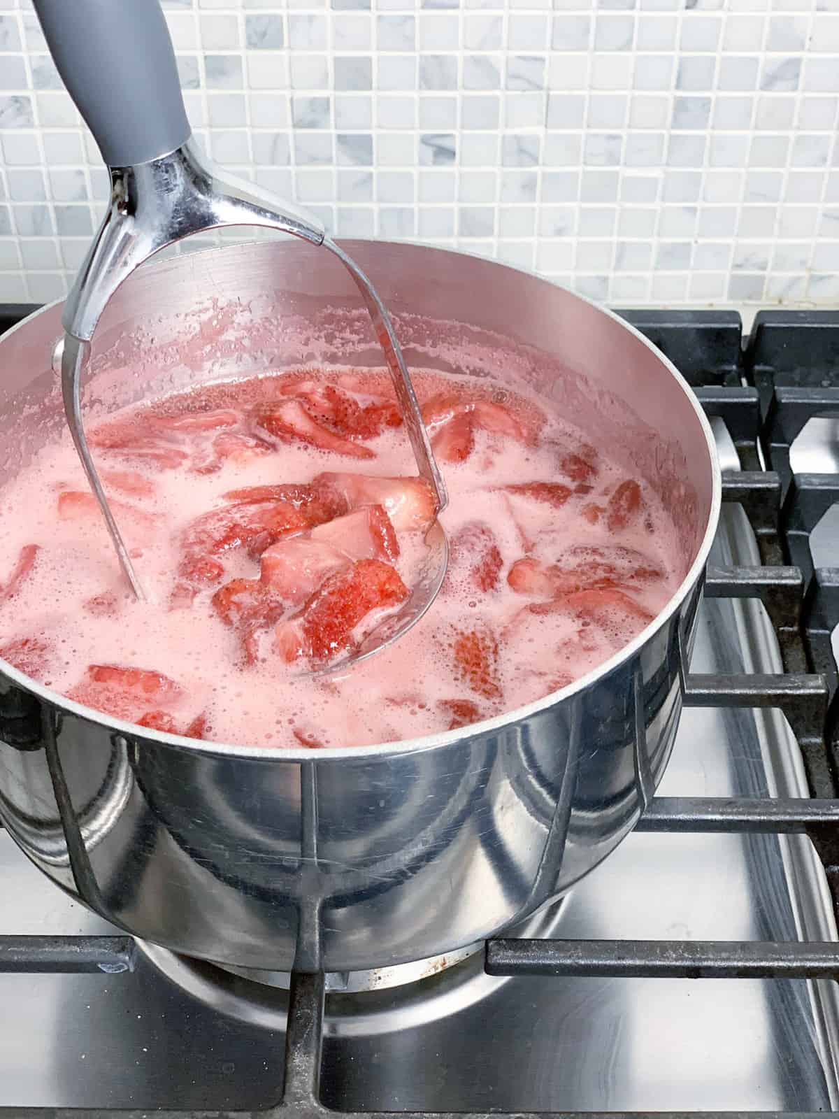 Use a potato masher to smoosh the strawberries