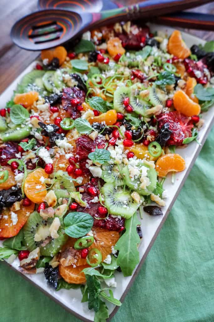 winter fruit salad with kiwis, mandarin oranges, citrus, pomegranate, and prunes