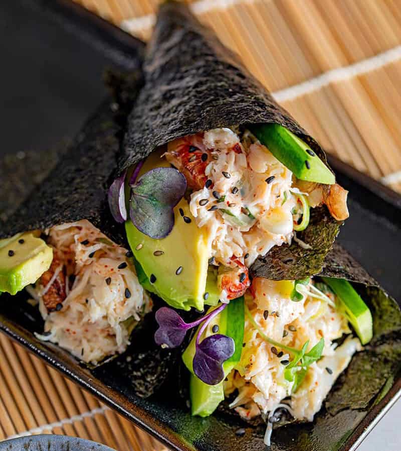 3 California hand rolls stacked on top of each other. This California avocados recipes is filled with crab and avocado.