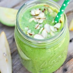 Green Smoothie with Leafy Greens like Spinach and almonds on top.