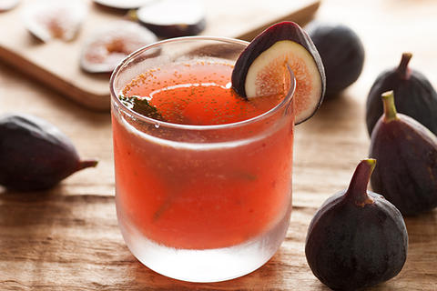 This fresh fig recipe is called the Flying Fig Cocktail. The pink cocktail has a slice of frehs fig on the rim of the glass.