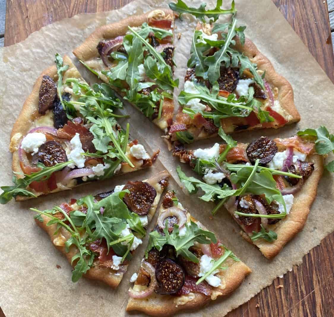 Pizza with dried Figs, arugula, feta, red onion, and bacon.