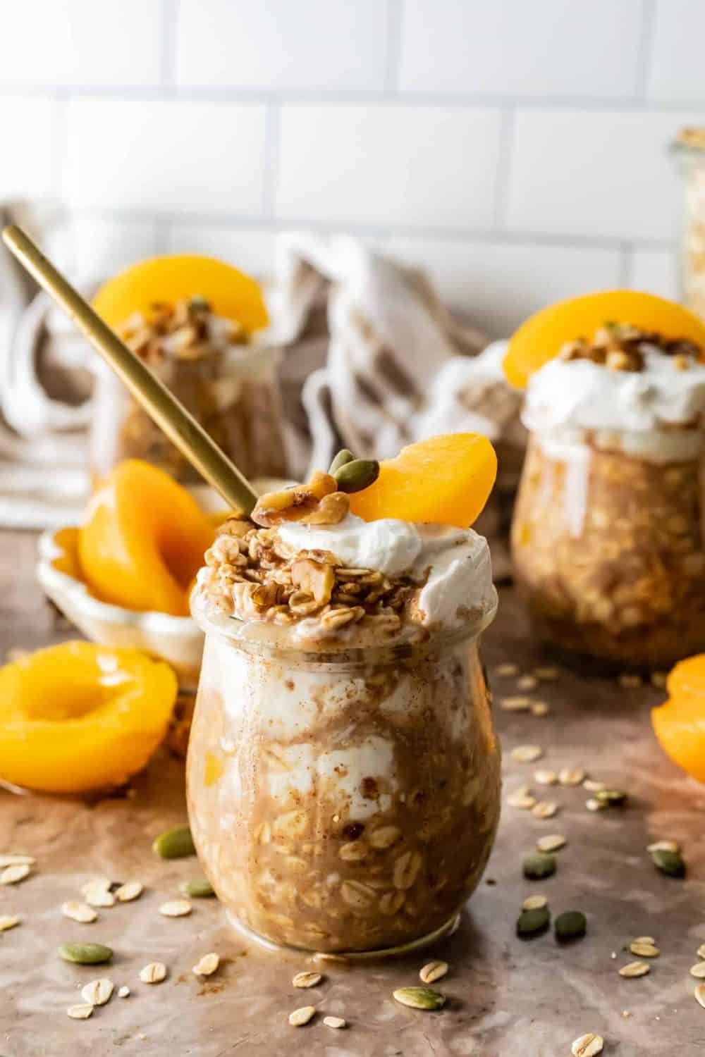 This recipe with canned peaches is for Peach Cobbler Overnight Oats. Glass jars are filled with overnight oats and topped with peach slices and yogurt .