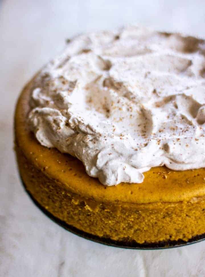 pumpkin cheesecake topped with whipped cream