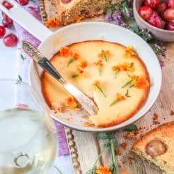 Baked Sweet Ricotta in a small baking dish sprinkled with edible flowers.