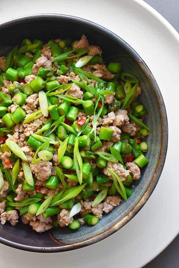 A bowl of prepared Spicy Pork and Asparagus Stir-Fry. Stir-fry is one of the best ways to cook asparagus.