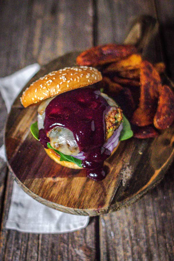 Blueberry Jalapeño BBQ sauce drizzled over the top of a turkey burger with spinach, red onion, and jalapeño jack cheese