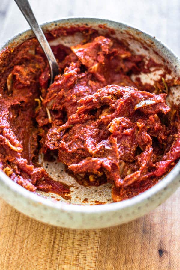 A bowl of tomato paste mixed with sliced garlic and spices for Melting Napa Cabbage.