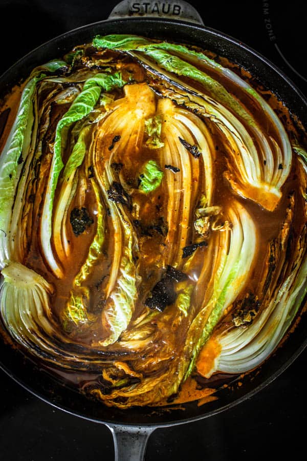 Seared Napa cabbage nestled into a rich tomato and garlic broth before being transferred to the oven to braise. 