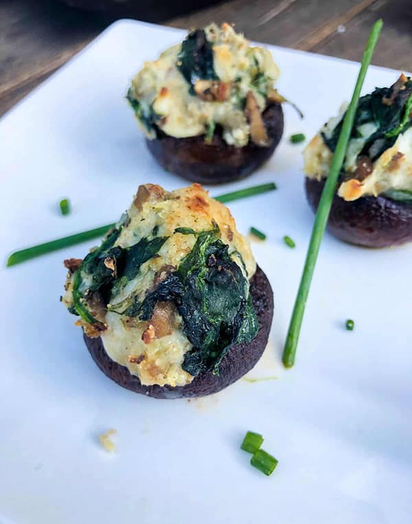 3 stuffed mushrooms with spinach and artichoke ready to serve.