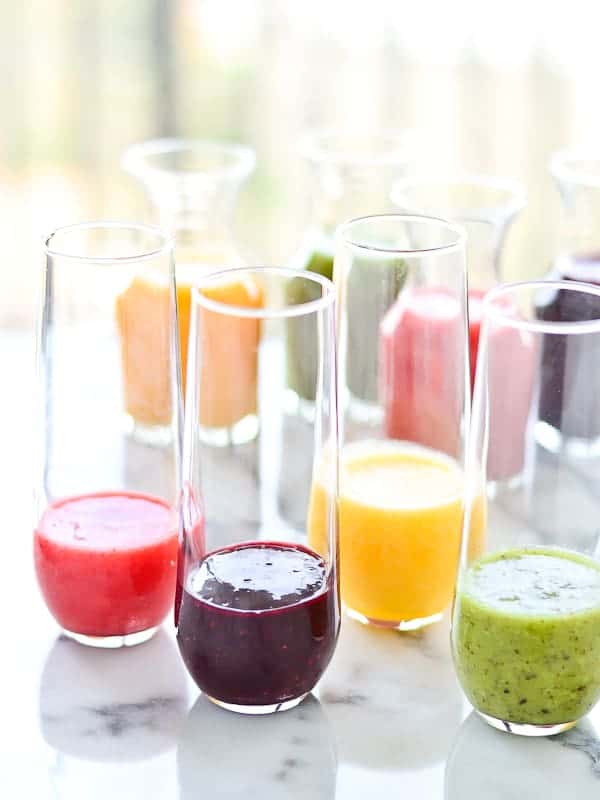 4 bellini glasses filled with different types of fruit puree for Bellinis. We haven't found a lot of bellini recipes with kiwi, but we love this one!