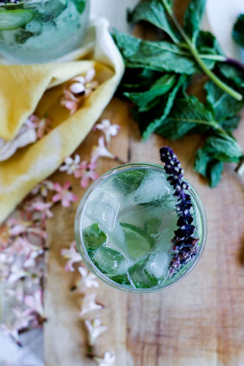A cocktail with cucumber and flowering purple basil,
