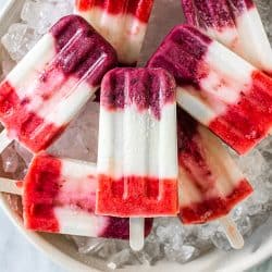 7 red, white, and blue popsicles in a bowl of ice.