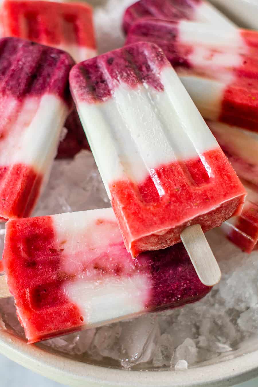 Red, white and blue popsicles in a bowl of ice.