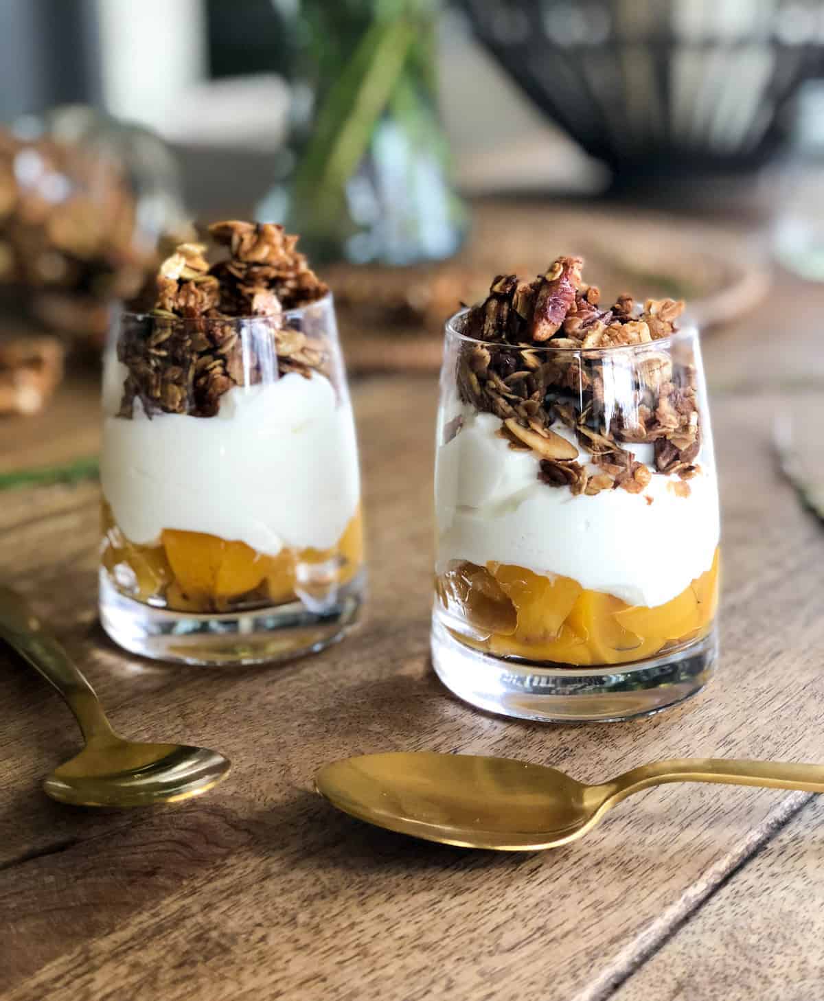 this recipe with canned peaches is a parfait in a clear glass with canned peaches on the bottom,  yogurt, and granola.