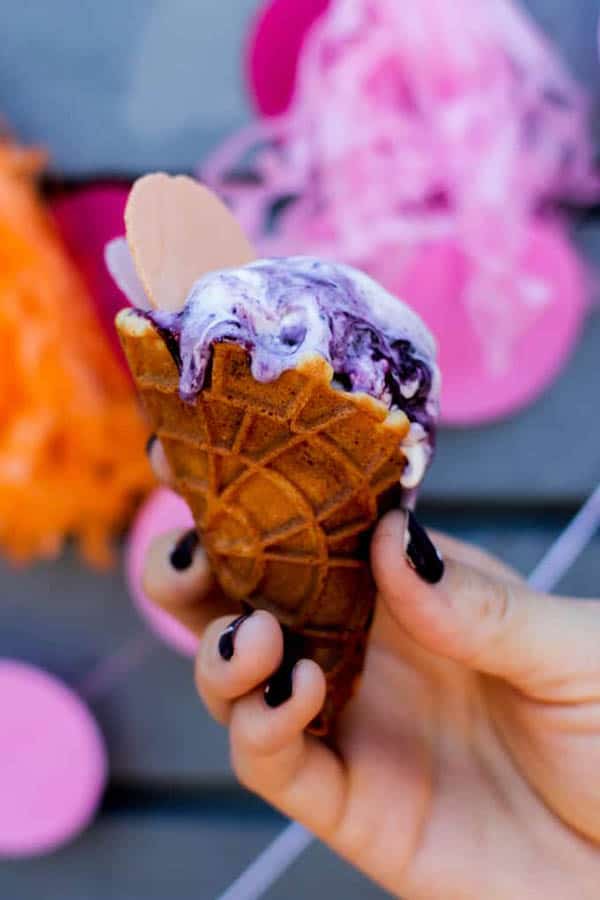 No churn blueberry ice cream served in a mini waffle cone. 