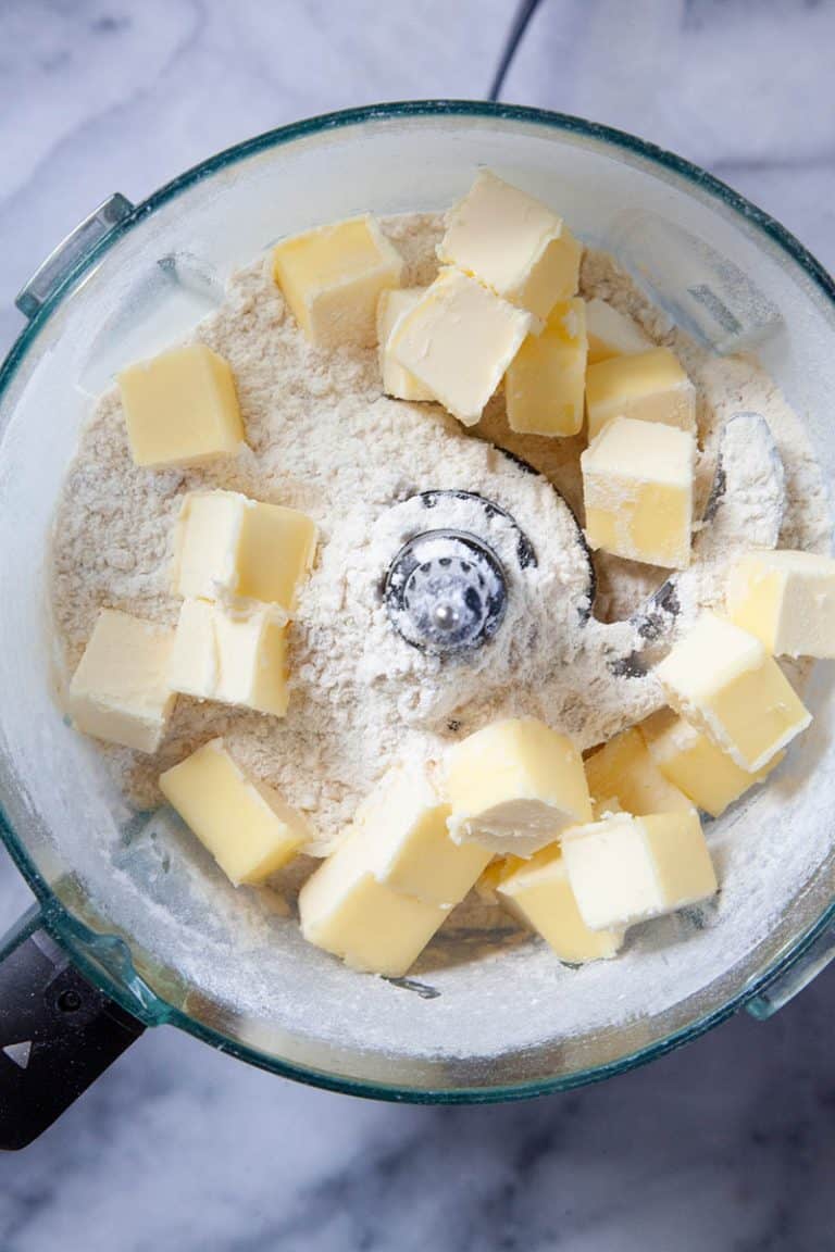 Chunks of butter in a food processor to make a walnut tart recipe.