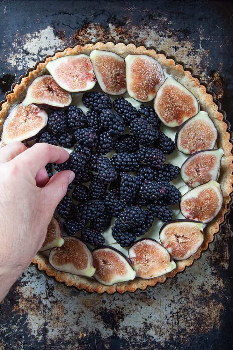 Figs and blackberries arranged on tart.