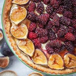 A close of our berry fig tart recipe. It is a walnut crust with a creamy filling that is topped with blackberries and figs.