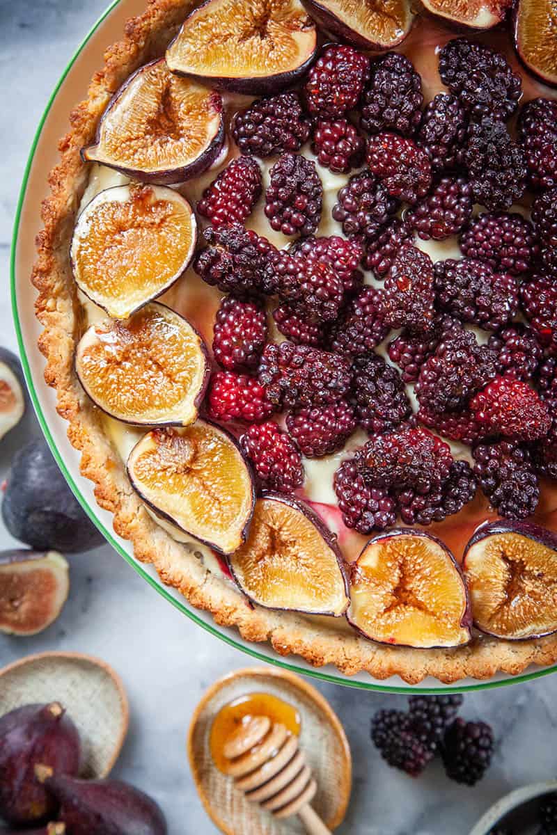 A close of our berry fig tart recipe. It is a walnut crust with a creamy filling that is topped with blackberries and figs.