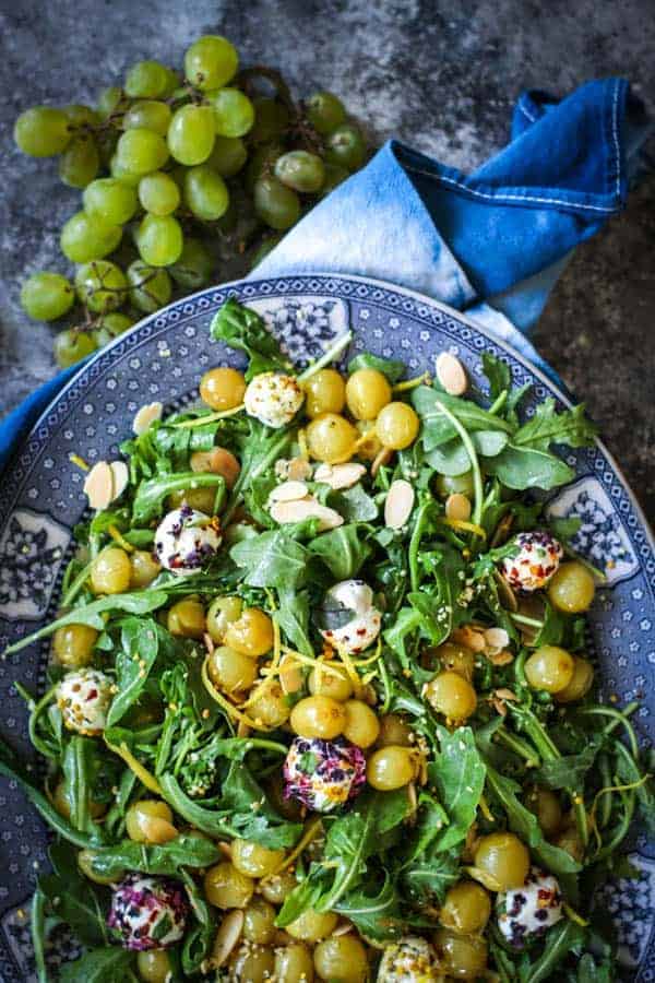 A platter of arugula, goat cheese and roasted grape salad.