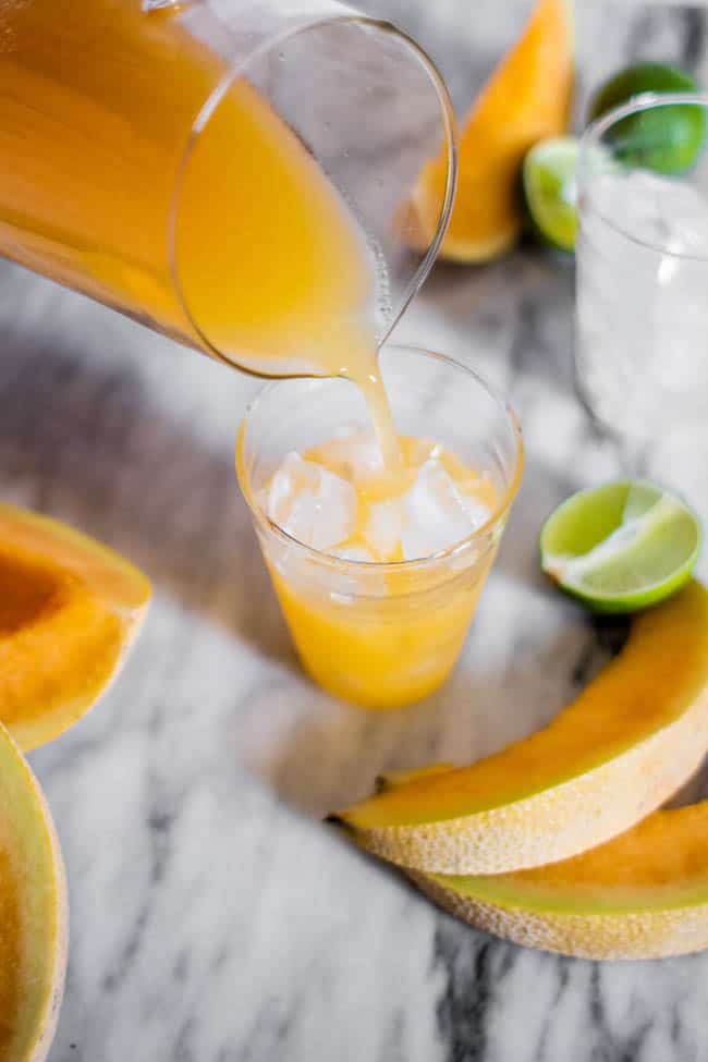 Pouring a glass of cantaloupe agua fresca.