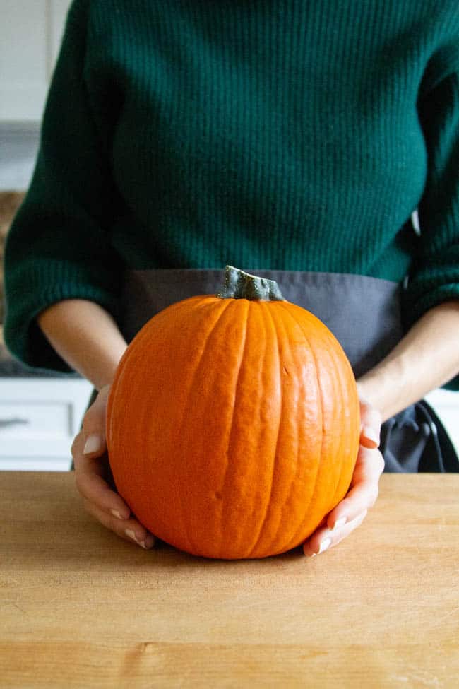 A woman holding a pumpkin
