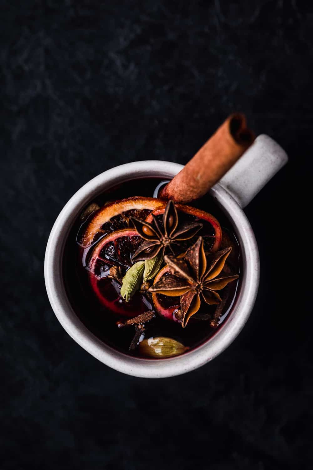 Spiced WIne and whole spices in a mug.