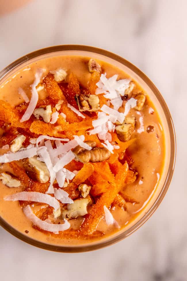 Carrot Cake Smoothie topped with shredded coconut, shredded carrots, crushed pecans.