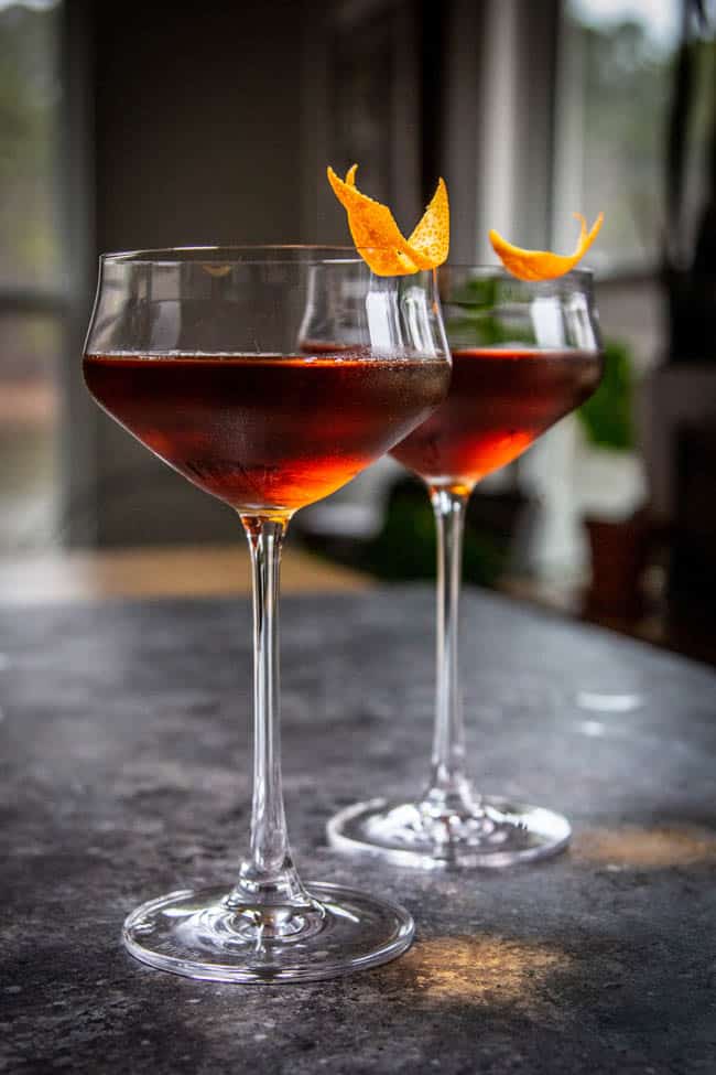 Two California-Style Adonis Cocktails with Vermouth and an orange garnish