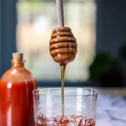 Drizzling hot honey into a glass.