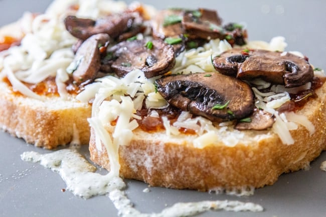 Grilled cheese on griddle with crispy mushrooms.