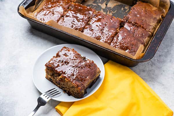 A Simple Recipe for Vintage Prune Cake with Glaze. A slice of prune cake on a plate from the pan. 