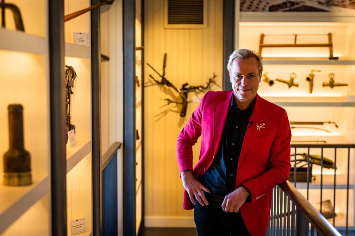 JC Boisset leaning on a staircase inside of the 1881 Napa Museum in Oakville, CA