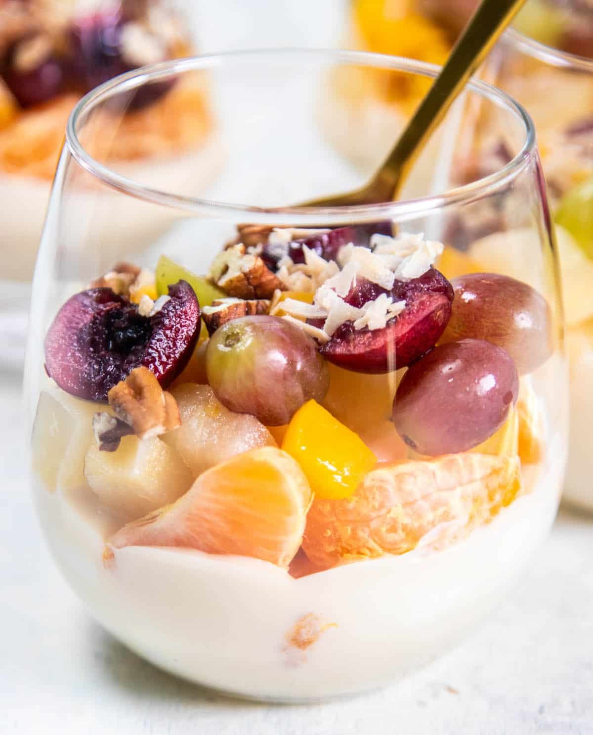 What to serve with baked eggs: A close up of layered Ambrosia Salad with mandarins, grapes, cherries, pears, and peaches.