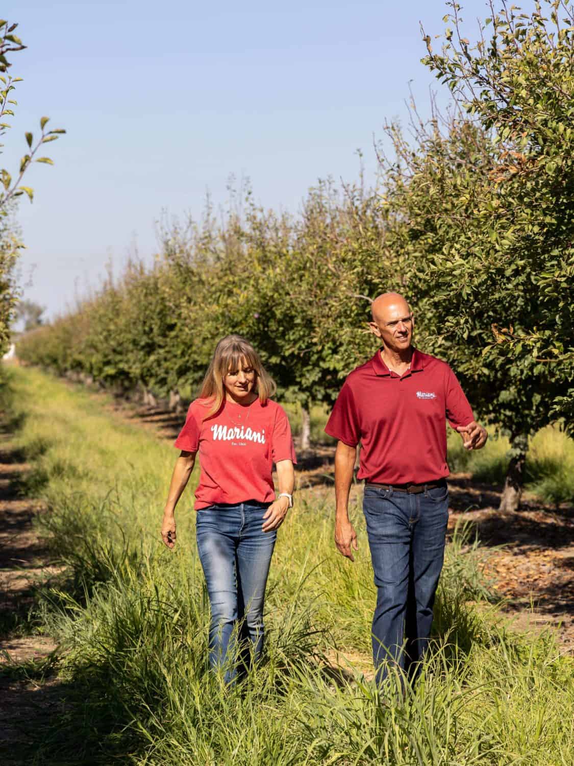 George Souza and Natalie Mariani Kling of Mariani Family farm walking through their Yuba City prune orchard