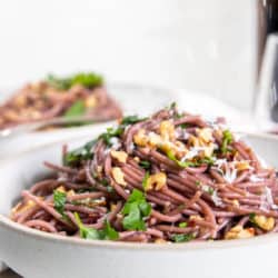 Red Wine Spaghetti topped with herbs, toasted walnuts, and cheese.