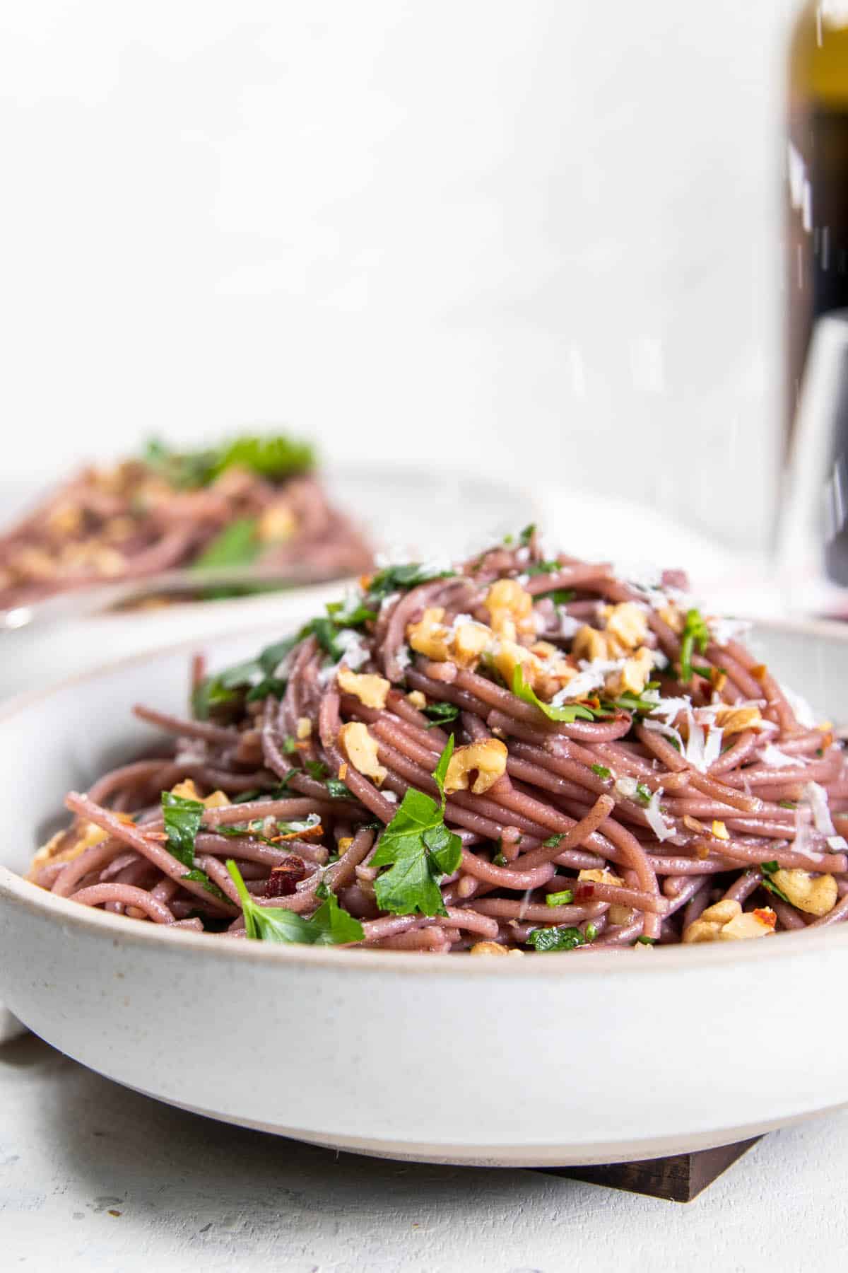 Red Wine Spaghetti topped with herbs, toasted walnuts, and cheese.