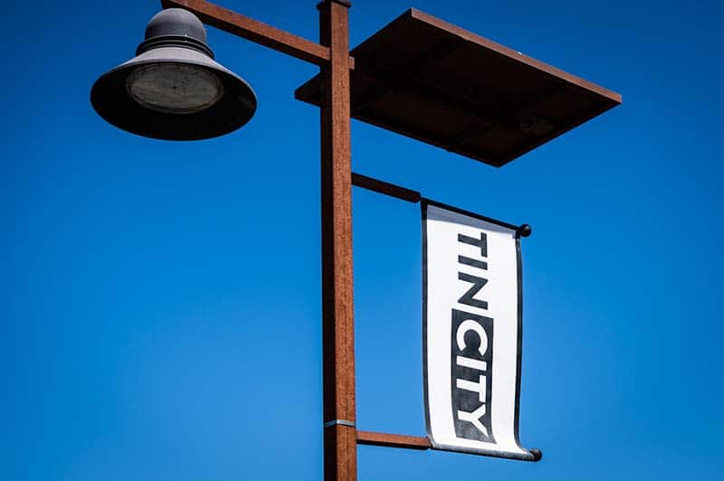 A sign on a light pole marking Tin CIty.