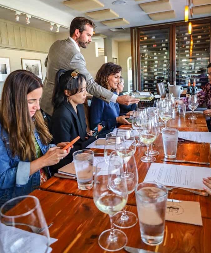 Table at Passionfish, a Monterey seafood restaurant, with wineglasses and influencers from the Monterey County California Wines Tour.